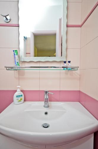 a white sink in a bathroom with a mirror at Ydreos Studios & Apartments in Mikri Vigla
