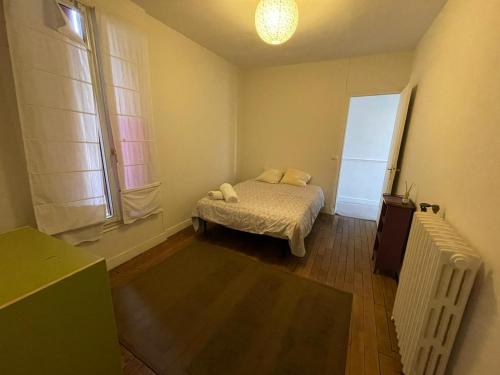 a small bedroom with a bed and a window at Agréable Maison Familiale in Arcueil