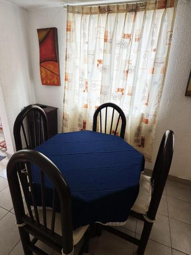 a table and chairs with a blue table and a curtain at Acogedor departamento cerca del metro guerrero e hidalgo in Mexico City