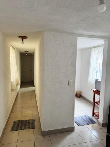 a hallway of a house with a door and a tile floor at Acogedor departamento cerca del metro guerrero e hidalgo in Mexico City