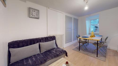 un salon avec un canapé et une table dans l'établissement Le Napoléon Mulhouse, à Mulhouse