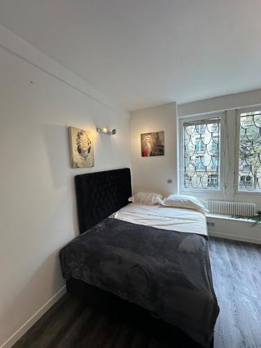 une chambre avec un lit et deux fenêtres dans l'établissement Beautiful Studio Paris Eiffel Tower, à Paris