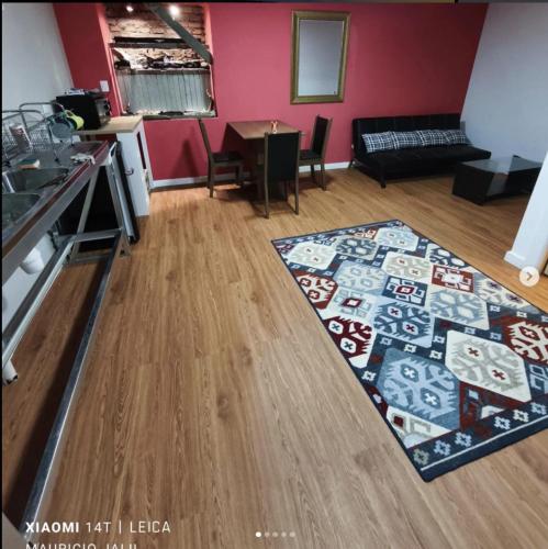 uma sala de estar com um tapete num piso de madeira em Aventura Patagonica 4 em Punta Arenas