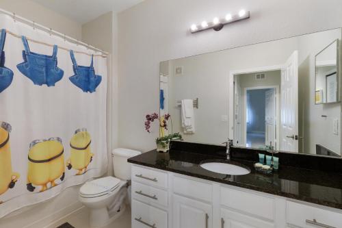 a bathroom with a sink and a toilet and a mirror at One in a Minion #102 in Orlando