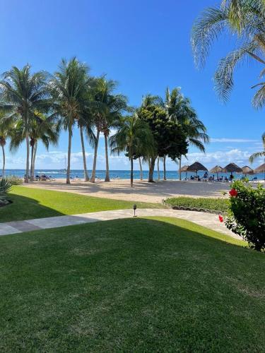 a person standing on a golf course near the beach at Residencias Reef in Cozumel