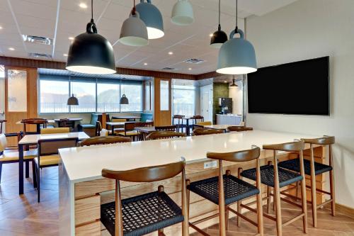 a restaurant with tables and chairs and a flat screen tv at Fairfield Inn & Suites by Marriott Dallas Love Field in Dallas