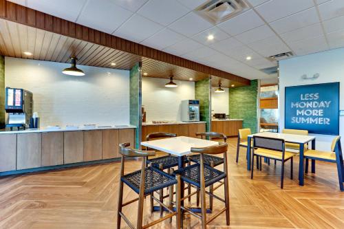a restaurant with tables and chairs and a counter at Fairfield Inn & Suites by Marriott Dallas Love Field in Dallas