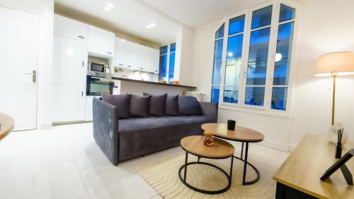 un salon avec un canapé et une table dans l'établissement Charming apartment in Levallois, à Levallois-Perret