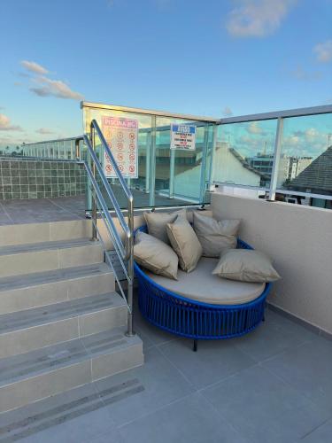 a bed with pillows on a balcony with stairs at EcoMirage - Flats Premium - Porto de Galinhas in Porto De Galinhas