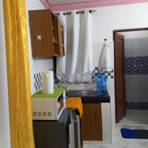 a small kitchen with a microwave and a sink at La-mia-casa in Mombasa