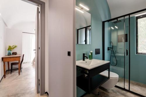 a bathroom with a sink and a glass shower at Tenuta Buganvillea -Private pool in Ostuni