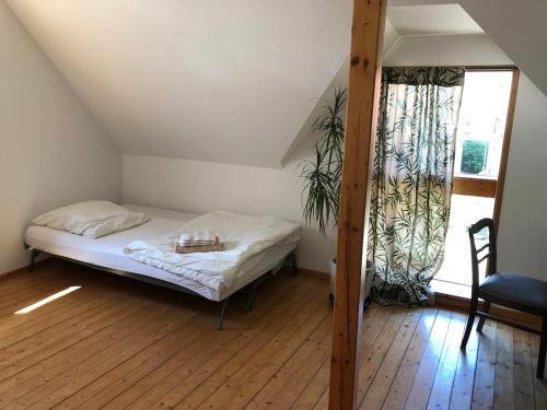 a small bedroom with a bed and a window at Pretty half-timbered cottage on romantic yard in Fuldabrück