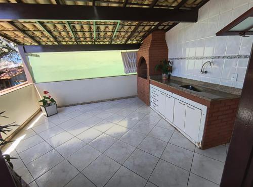 a large kitchen with a sink and a window at Casa Da Praça Independência in Arraial do Cabo