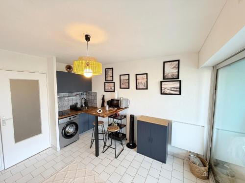 une cuisine avec un comptoir et un lave-linge/sèche-linge dans l'établissement Appart Grande motte Quartier Couchant - Parking - Balcon- Piscine - Plage 300m, à La Grande Motte