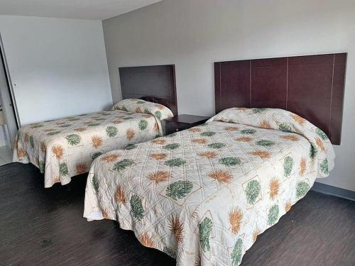 Dos camas en una habitación de hotel con en DELUXE INN augusta, en Augusta
