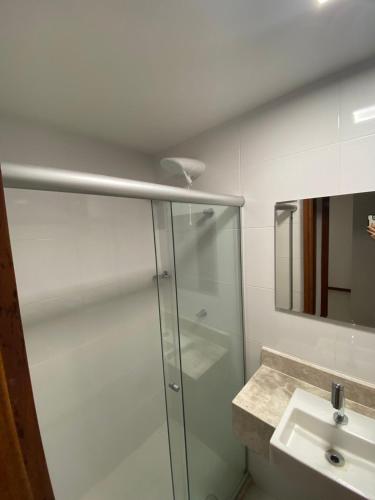 a bathroom with a glass shower and a sink at Recanto Brisas de Imbassaí Village C18 in Mata de Sao Joao