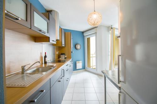 - une cuisine avec des placards blancs et des murs bleus dans l'établissement Palestro -St charles- Vieux Port, à Marseille