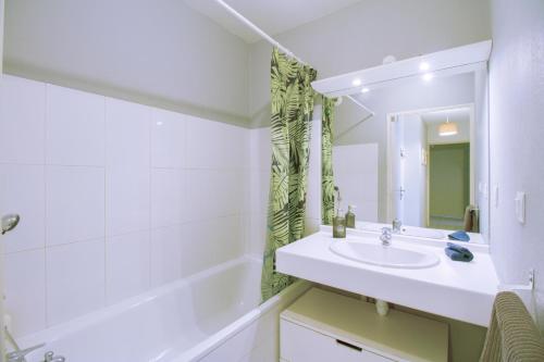 La salle de bains blanche est pourvue d'un lavabo et d'une baignoire. dans l'établissement Palestro -St charles- Vieux Port, à Marseille