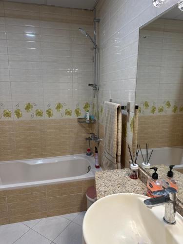 シャルジャにあるCloudsの洗面台、浴槽、鏡のあるバスルーム