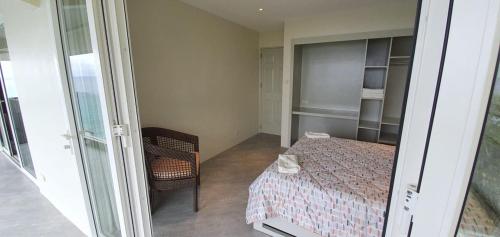 a small bedroom with a bed and a chair at Noor Villa - Luxury 3 Bed, 2 Bath Apartment with Stunning Panoramic Sea View, Private Beach in Pinamihagan