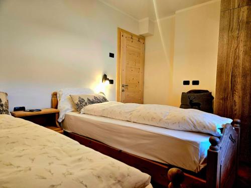 a bedroom with two beds and a door at Sunrise Livigno in Livigno