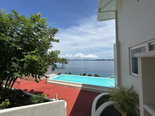 a swimming pool on the side of a building next to the water at Amal Villa - Luxury 2 Bed, 2 Bath Apartment with Panoramic Ocean Views, Peaceful, Private Beach in San Jose