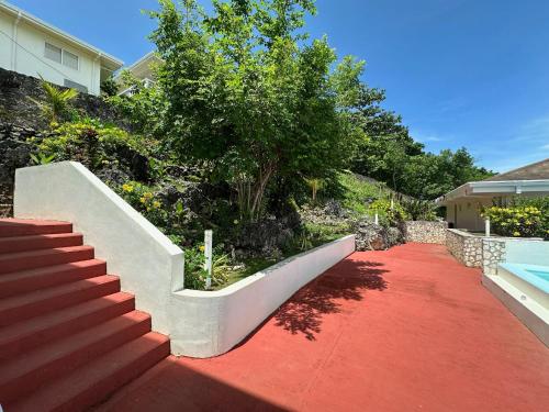 a red carpeted walkway with a staircase next to a house at Amal Villa - Luxury 2 Bed, 2 Bath Apartment with Panoramic Ocean Views, Peaceful, Private Beach in San Jose