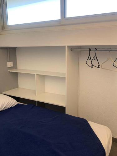 - une chambre avec un lit, une fenêtre et des étagères dans l'établissement Résidence Port Nature Colline 1 - Appartement T2 4 pers. - Port Nature Colline 1 MAE-2794, au Cap d'Agde