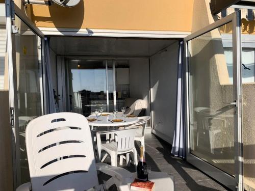 un patio avec une table et des chaises sur un balcon dans l'établissement Résidence Port Nature Colline 3 - Appartement T2 4 pers - Port Nature Colline 3 MAE-2874, au Cap d'Agde