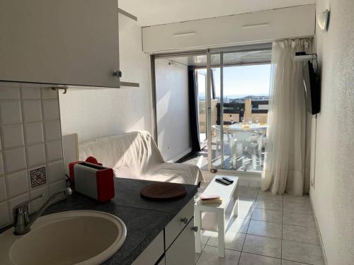łazienka z umywalką i salon w obiekcie Résidence Port Nature Colline 3 - Appartement T2 4 pers - Port Nature Colline 3 MAE-2874 w Cap d'Agde
