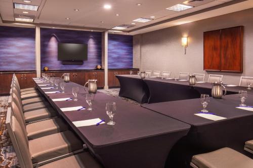 a conference room with tables and chairs and a flat screen tv at Delta Hotels by Marriott Chesapeake Norfolk in Chesapeake