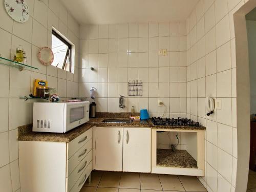 una cucina con un lavandino e un microonde di Casa de 2 Suítes com Internet Rápida e Comodidades a Belo Horizonte