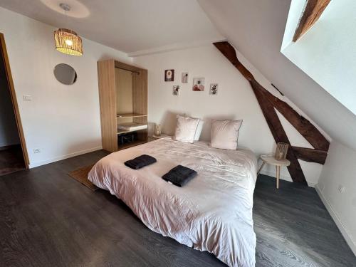 une chambre avec un grand lit dans un grenier dans l'établissement La Ruche, à La ForestiÃ¨re