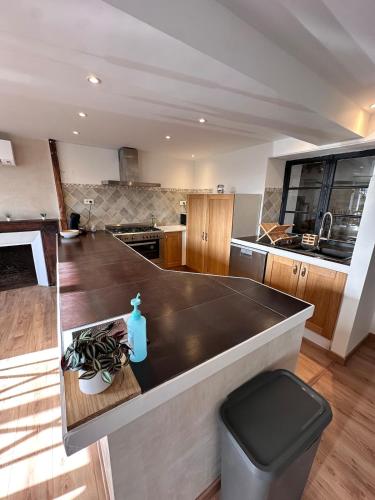 une cuisine avec un grand îlot au milieu dans l'établissement La Ruche, à La ForestiÃ¨re