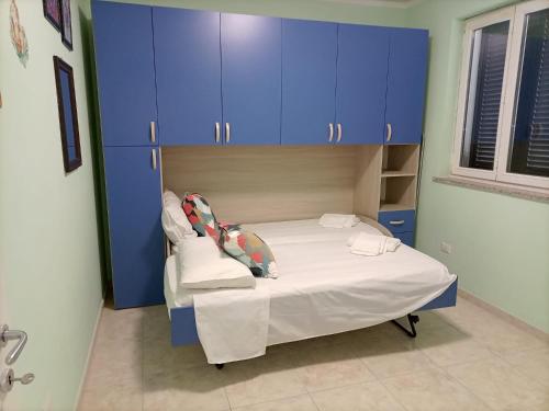 a bedroom with blue cabinets and a white bed at Villa Vaide in Baronissi