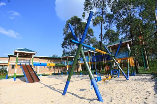 a playground with slides and swings in front of a building at Theron Leisure Park & Residences in Kalungu
