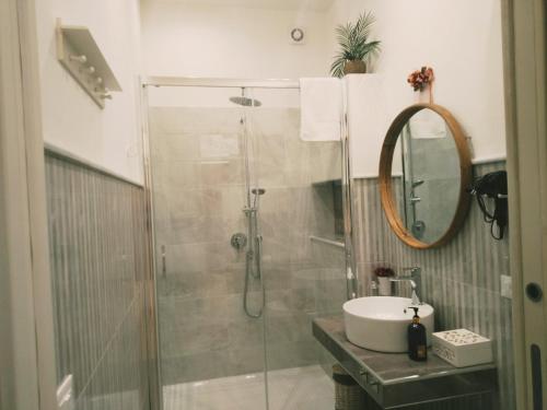 a bathroom with a shower with a sink and a mirror at Nonno Turiddu Elegant Rooms in Caccamo