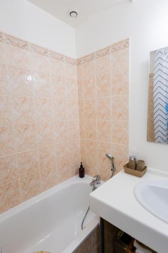 une salle de bain avec une baignoire et un lavabo dans l'établissement Appartement Jelyad Angelus proche Disney, à Chanteloup-en-Brie