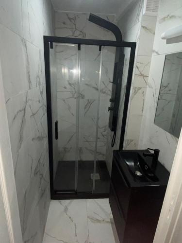 une douche avec une porte vitrée dans une salle de bain dans l'établissement Joli maison refait à neuf #2, à Vierzon