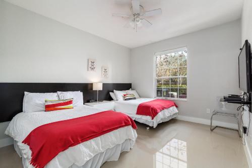 a bedroom with two beds with red and white sheets at Mickey Mouse #104 in Orlando