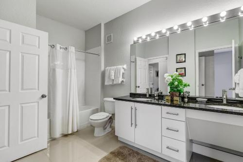 a bathroom with a sink and a toilet and a mirror at Mickey Mouse #104 in Orlando