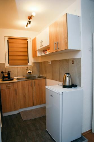 a kitchen with wooden cabinets and a white refrigerator at Filip in Slavonski Brod