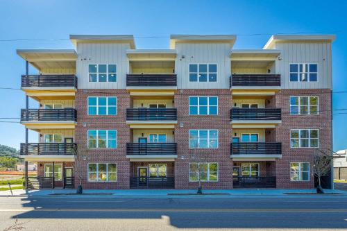a tall red brick building with balconies at Chic 2BR at The Poplin - Southside Chattanooga in Chattanooga