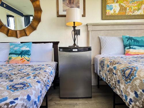 a hotel room with two beds and a mirror at Hawaii Movie Studio WaikikiSeaside4person in Honolulu