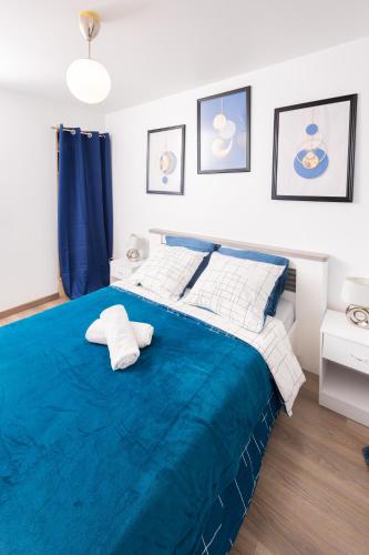 - une chambre avec un lit bleu et 2 oreillers dans l'établissement Appartement Jelyad Mallard proche Disney, à Chanteloup-en-Brie