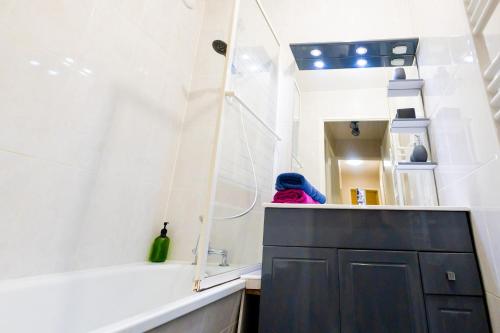 a bathroom with a black cabinet and a bath tub at Appartement Jelyad Mallard proche Disney in Chanteloup-en-Brie