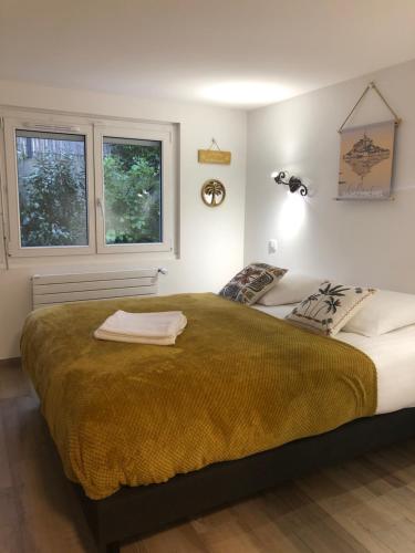 une chambre avec un grand lit et deux fenêtres dans l'établissement La Frégate, à Saint-Malo