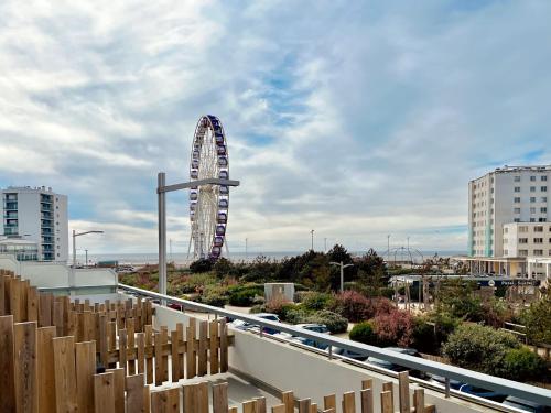 a ferris wheel in the middle of a city at Hôtel Le Littoral - Berck sur Mer in Berck-sur-Mer