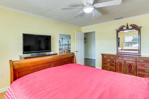 a bedroom with a bed and a flat screen tv at Spacious Canalfront Home with Pool about half Mi to Beach in Hudson
