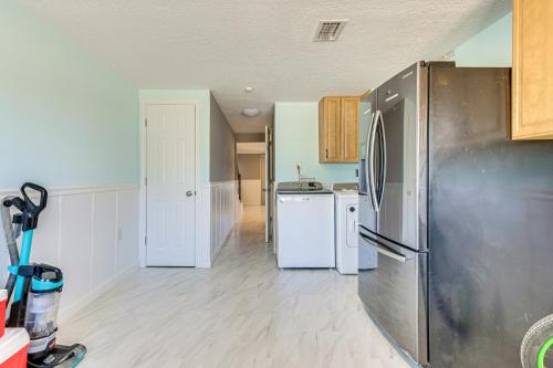 a kitchen with a stainless steel refrigerator and white appliances at Spacious Canalfront Home with Pool about half Mi to Beach in Hudson